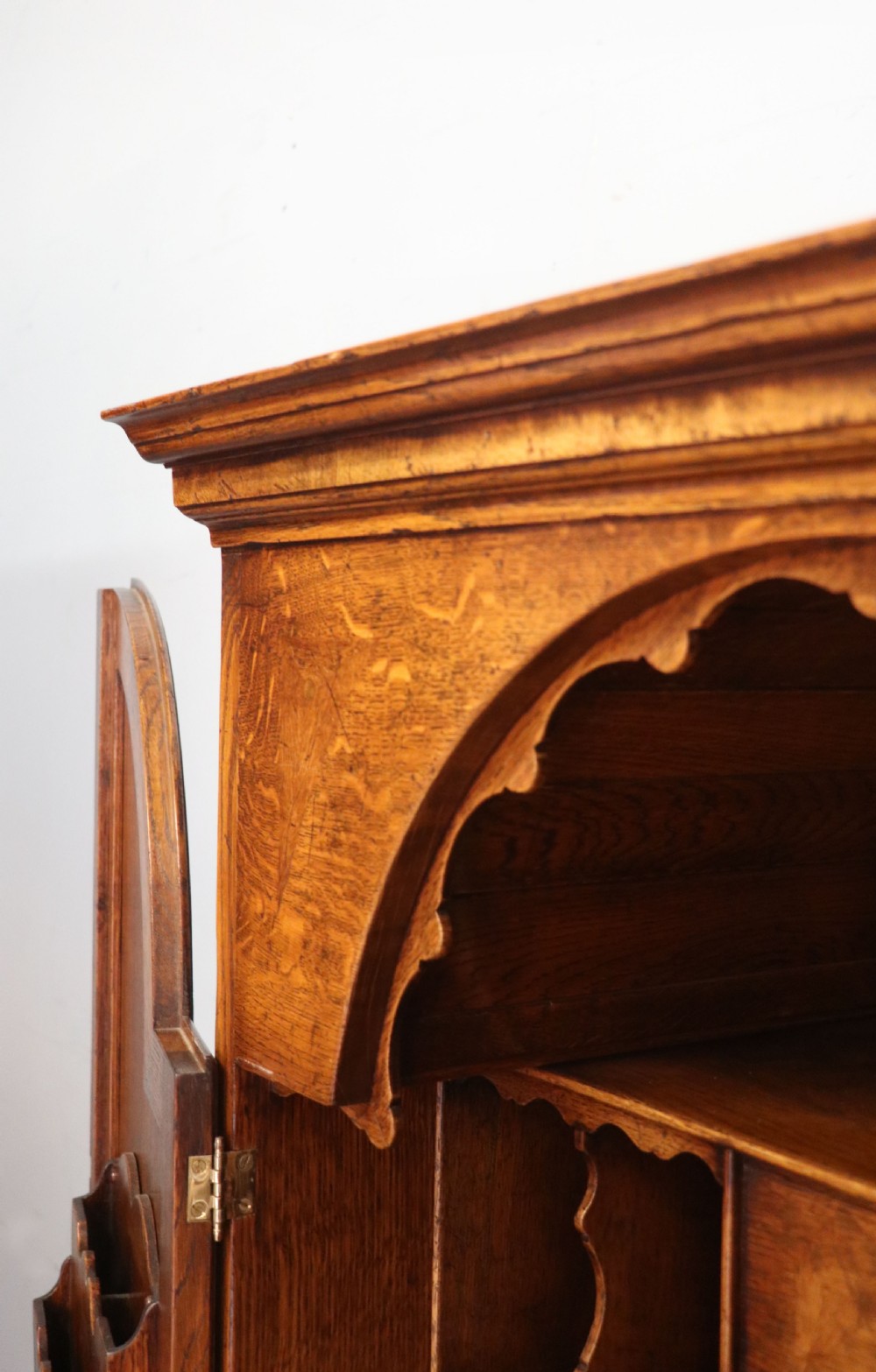 A Georgian style warm brown oak bureau cabinet featuring two upper arched doors opening to a fitted interior of pigeonholes and small drawers above three long drawers with brass handles. View XIII
