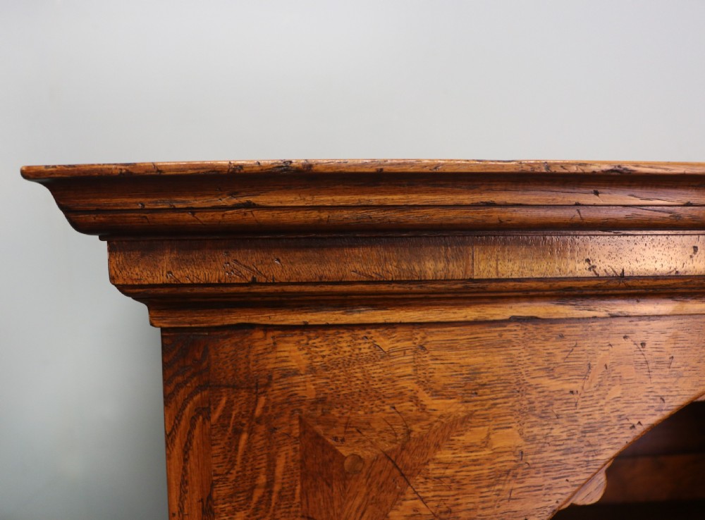 A Georgian style warm brown oak bureau cabinet featuring two upper arched doors opening to a fitted interior of pigeonholes and small drawers above three long drawers with brass handles. View XIV
