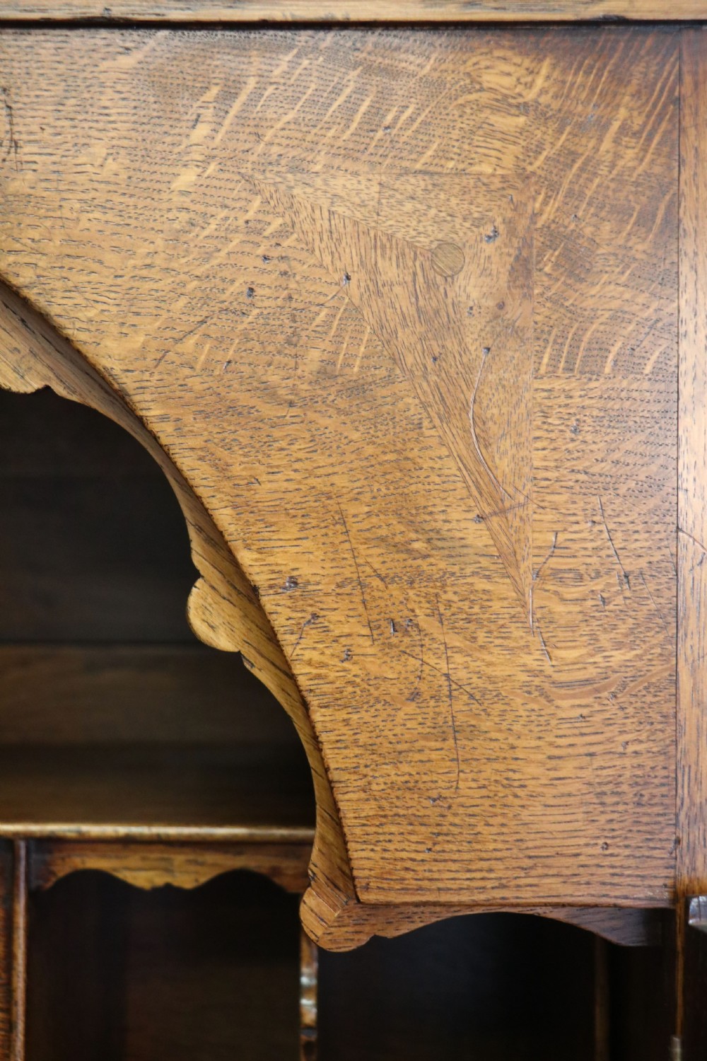 A Georgian style warm brown oak bureau cabinet featuring two upper arched doors opening to a fitted interior of pigeonholes and small drawers above three long drawers with brass handles. View XVII