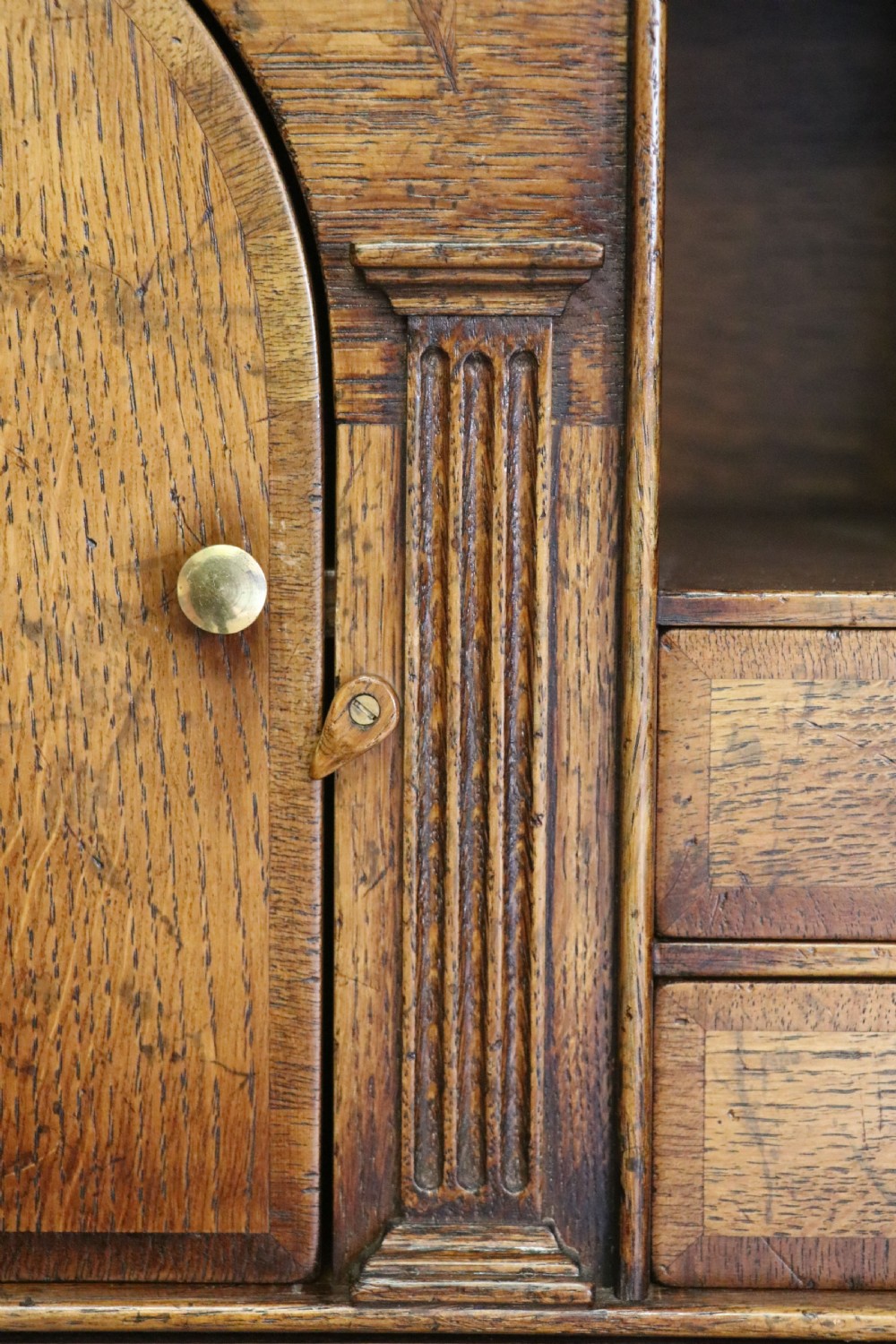A Georgian style warm brown oak bureau cabinet featuring two upper arched doors opening to a fitted interior of pigeonholes and small drawers above three long drawers with brass handles. View XX