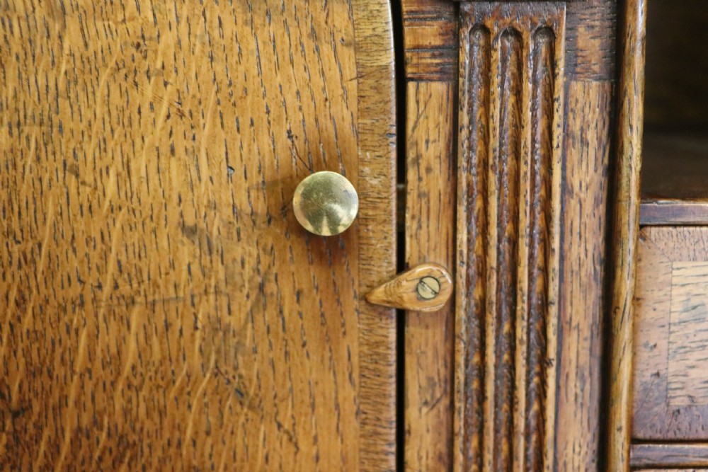 A Georgian style warm brown oak bureau cabinet featuring two upper arched doors opening to a fitted interior of pigeonholes and small drawers above three long drawers with brass handles. View XXVI