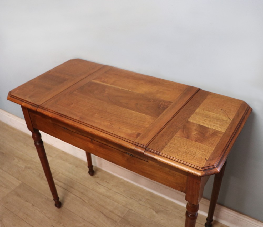 A brown walnut metamorphic writing desk featuring turned legs, side flaps, and an open top section exposing internal stationery compartments. View VIII