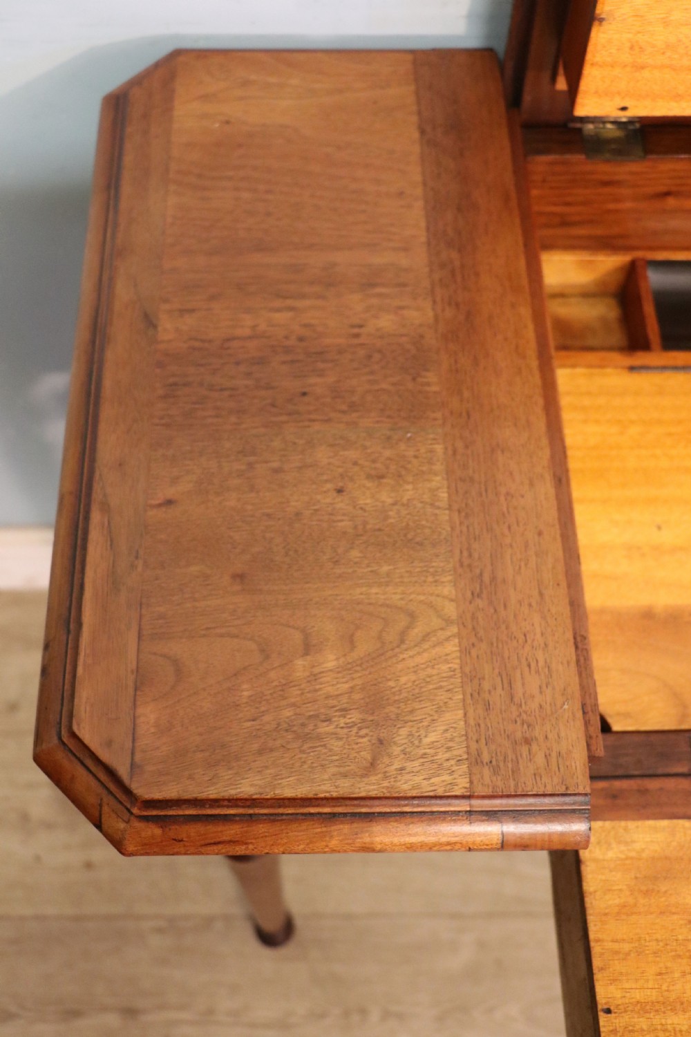 A brown walnut metamorphic writing desk featuring turned legs, side flaps, and an open top section exposing internal stationery compartments. View XI