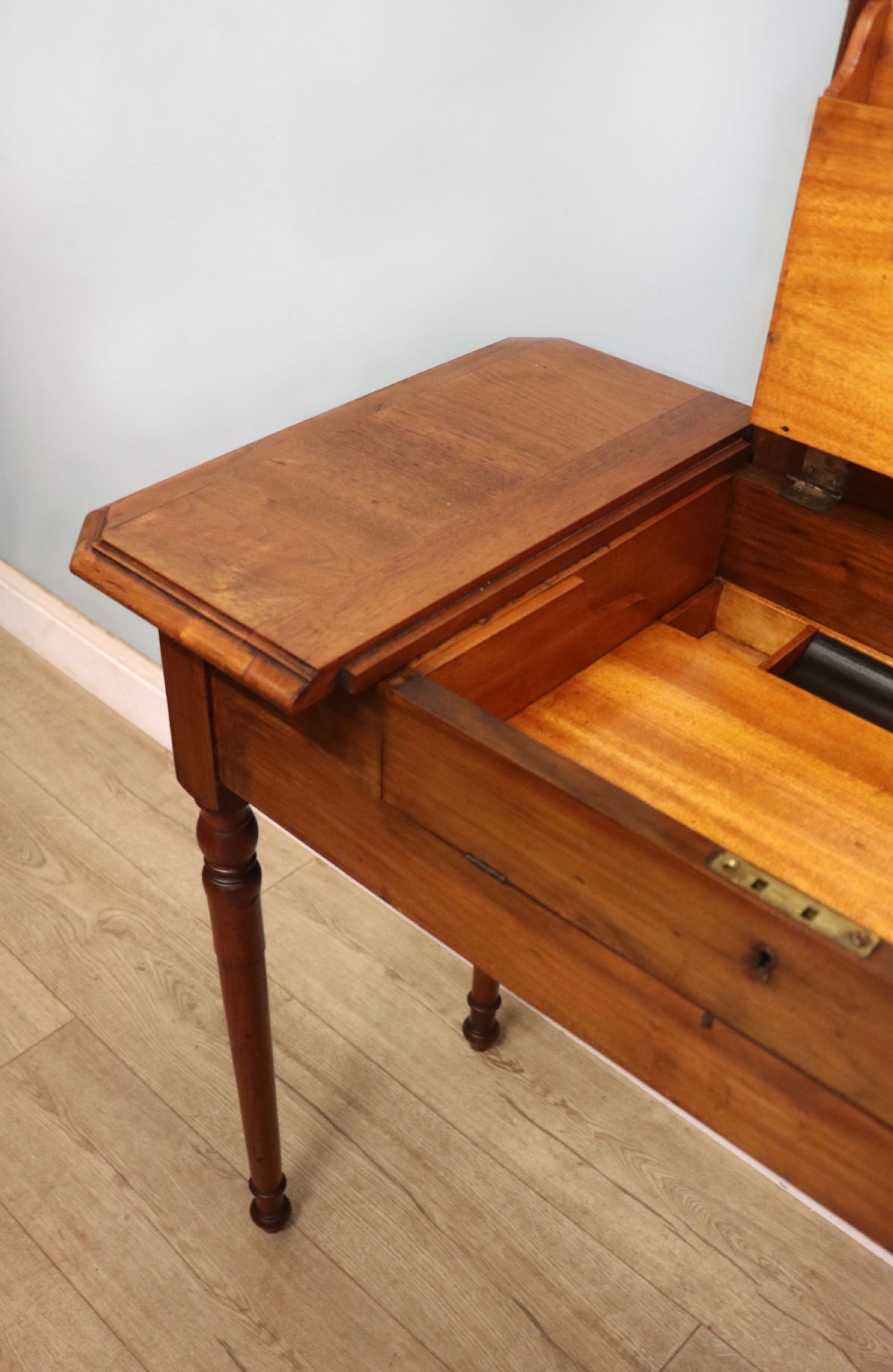 A brown walnut metamorphic writing desk featuring turned legs, side flaps, and an open top section exposing internal stationery compartments. View XII