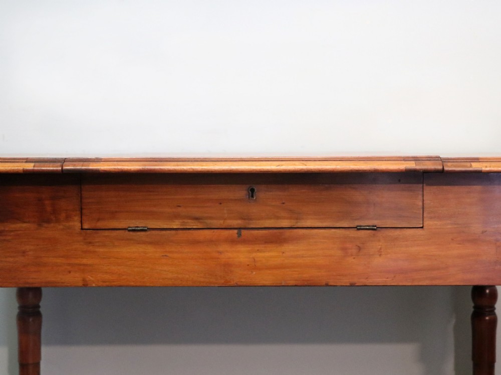 A brown walnut metamorphic writing desk featuring turned legs, side flaps, and an open top section exposing internal stationery compartments. View XIV