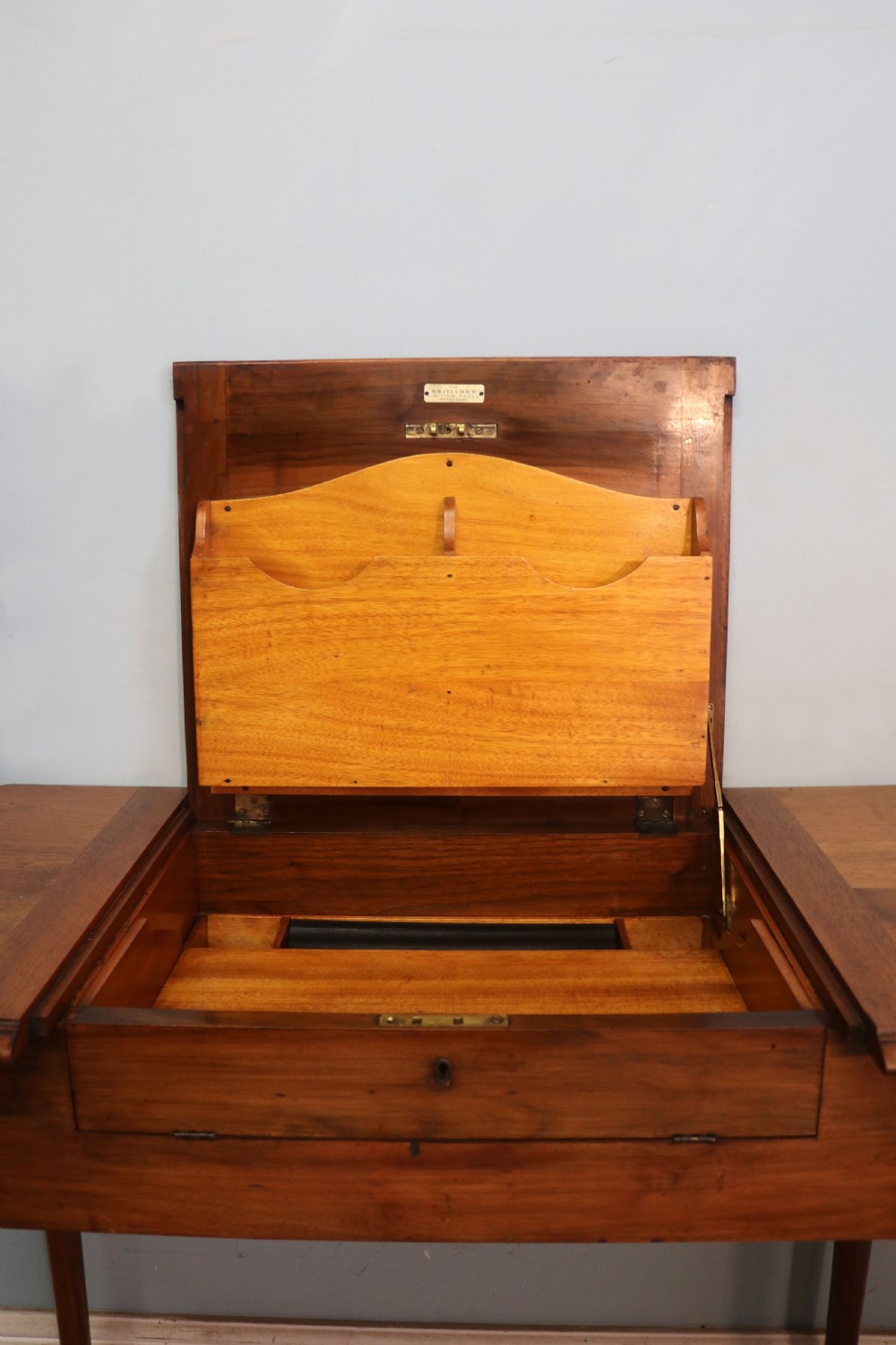 A brown walnut metamorphic writing desk featuring turned legs, side flaps, and an open top section exposing internal stationery compartments. View XVI