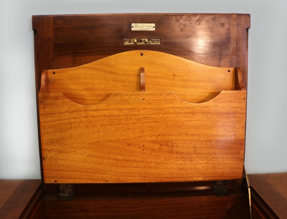 A brown walnut metamorphic writing desk featuring turned legs, side flaps, and an open top section exposing internal stationery compartments. View XVII