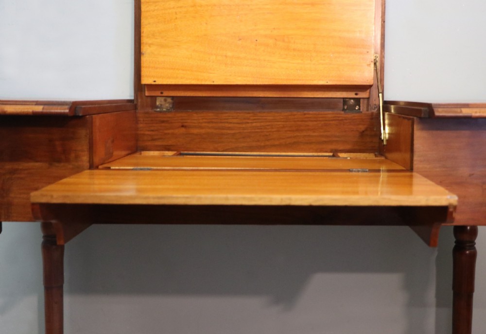A brown walnut metamorphic writing desk featuring turned legs, side flaps, and an open top section exposing internal stationery compartments. View XXIV