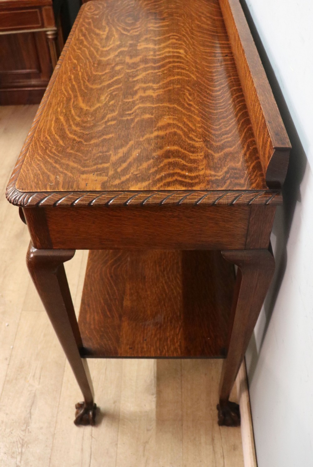 A Georgian revival oak side table featuring a single drawer with brass knobs, a lower tier shelf, and cabriole legs terminating in carved claw and ball feet. View VIII