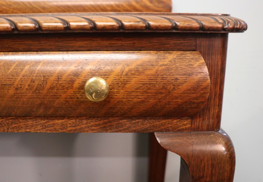 A Georgian revival oak side table featuring a single drawer with brass knobs, a lower tier shelf, and cabriole legs terminating in carved claw and ball feet. View XIV