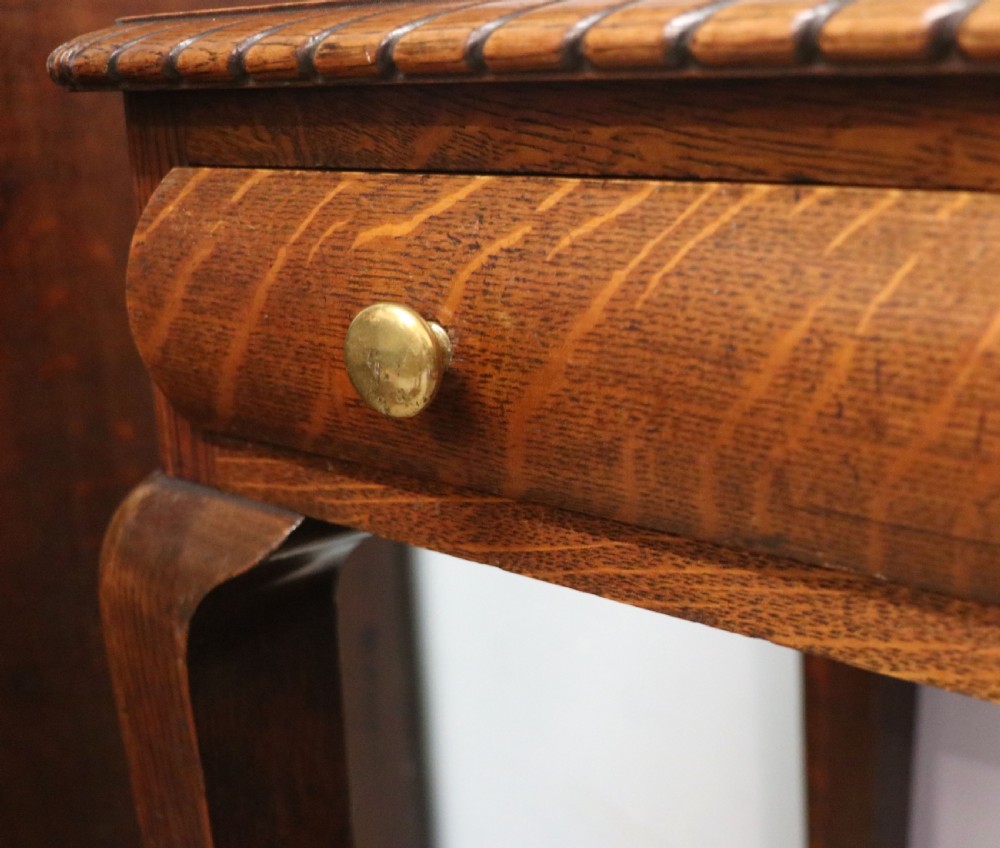 A Georgian revival oak side table featuring a single drawer with brass knobs, a lower tier shelf, and cabriole legs terminating in carved claw and ball feet. View XV