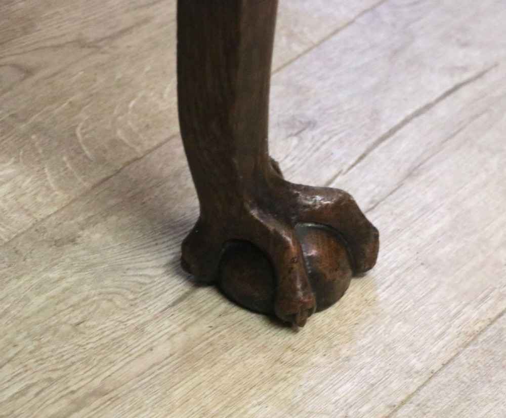 A Georgian revival oak side table featuring a single drawer with brass knobs, a lower tier shelf, and cabriole legs terminating in carved claw and ball feet. View XVII