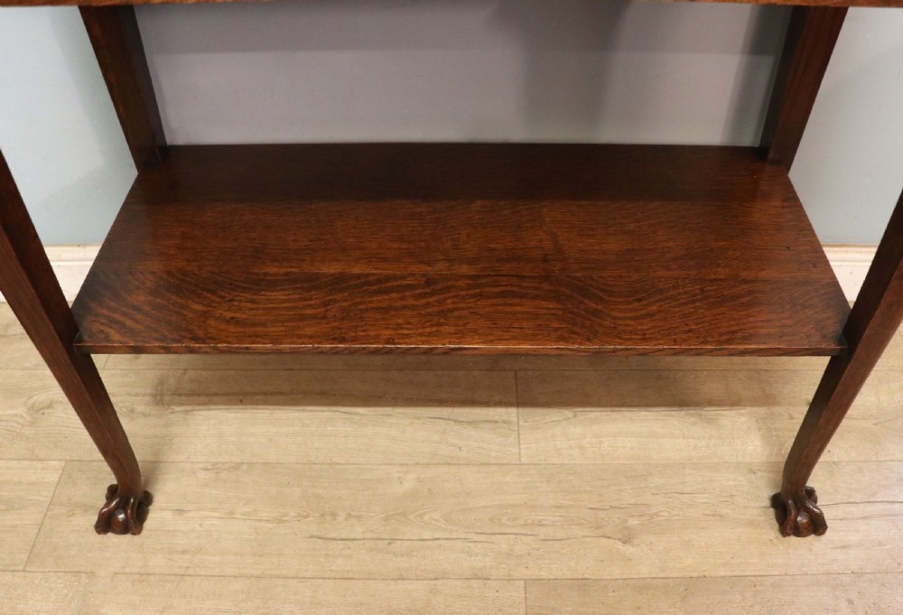 A Georgian revival oak side table featuring a single drawer with brass knobs, a lower tier shelf, and cabriole legs terminating in carved claw and ball feet. View XIX