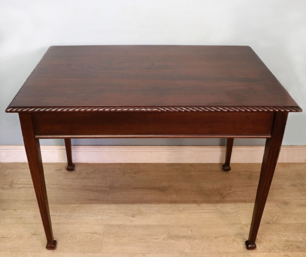An Edwardian rectangular mahogany side table featuring carved rope-twist edging and square tapered legs.