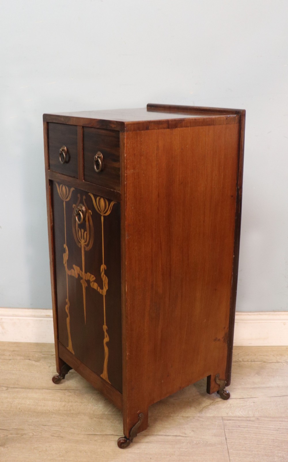 A tall dark wood Art Nouveau coal box featuring botanical marquetry inlay and brass ring handles, supported on castors. View XIII