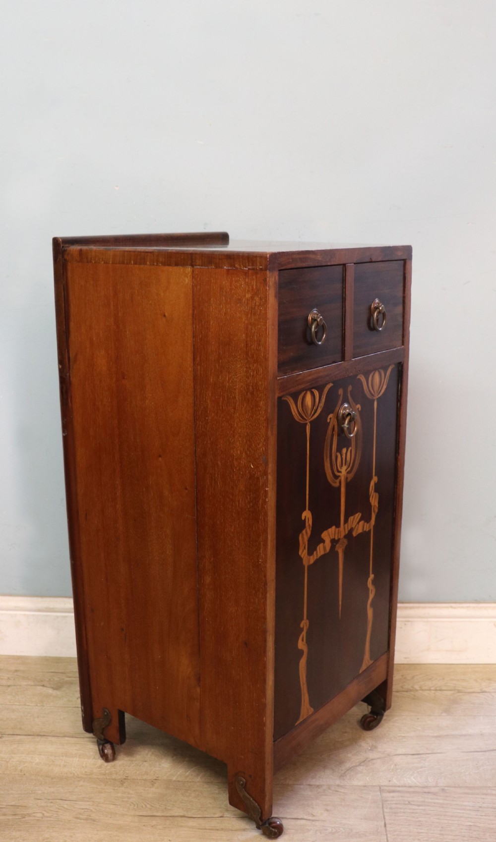 A tall dark wood Art Nouveau coal box featuring botanical marquetry inlay and brass ring handles, supported on castors. View XVII