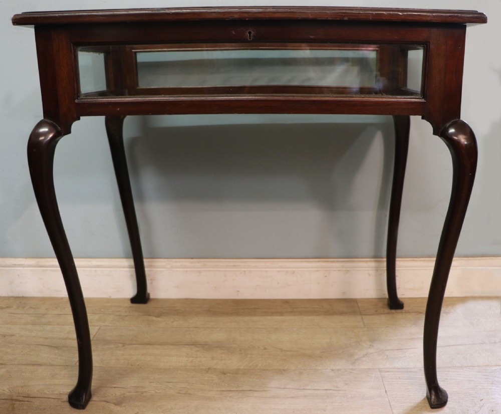 A dark mahogany glazed bijouterie table featuring cabriole legs, a glass top with blue Breitling watch branding, and a lined interior display compartment. View II