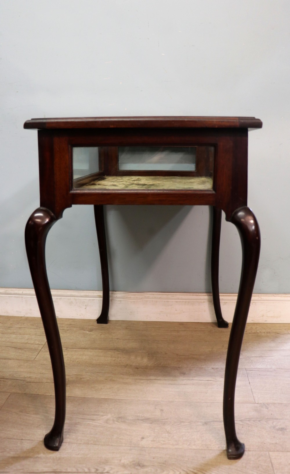 A dark mahogany glazed bijouterie table featuring cabriole legs, a glass top with blue Breitling watch branding, and a lined interior display compartment. View V