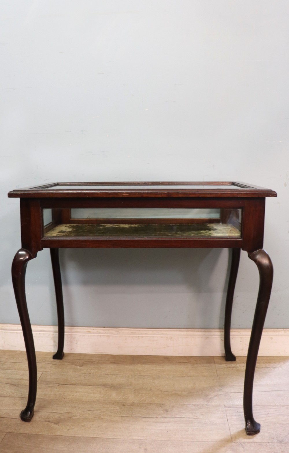 A dark mahogany glazed bijouterie table featuring cabriole legs, a glass top with blue Breitling watch branding, and a lined interior display compartment. View VIII
