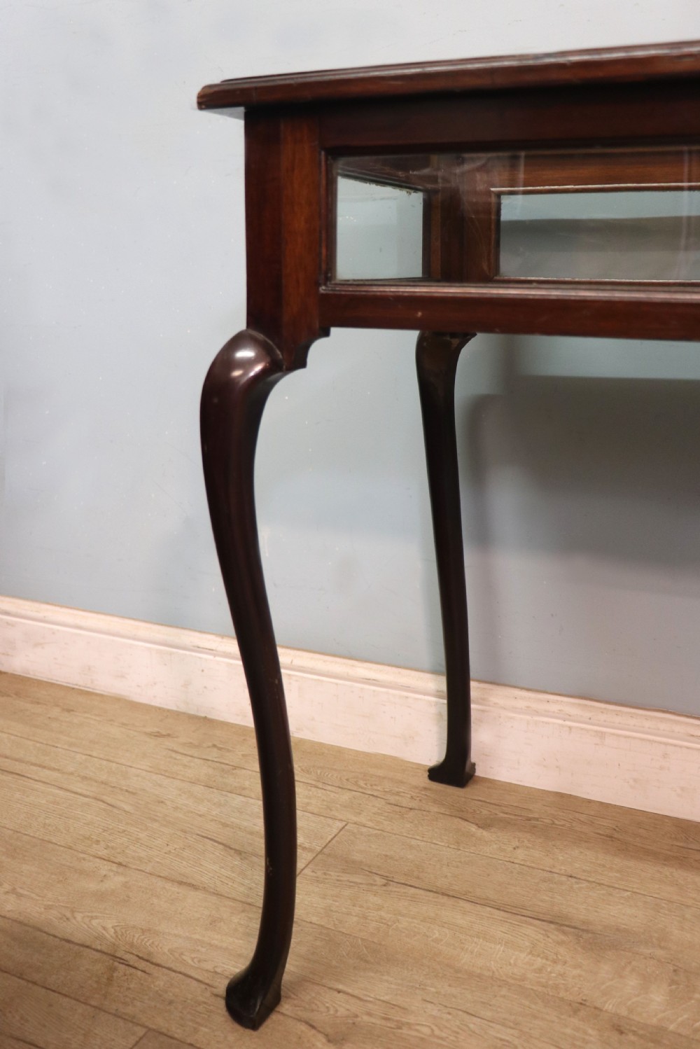 A dark mahogany glazed bijouterie table featuring cabriole legs, a glass top with blue Breitling watch branding, and a lined interior display compartment. View XIII