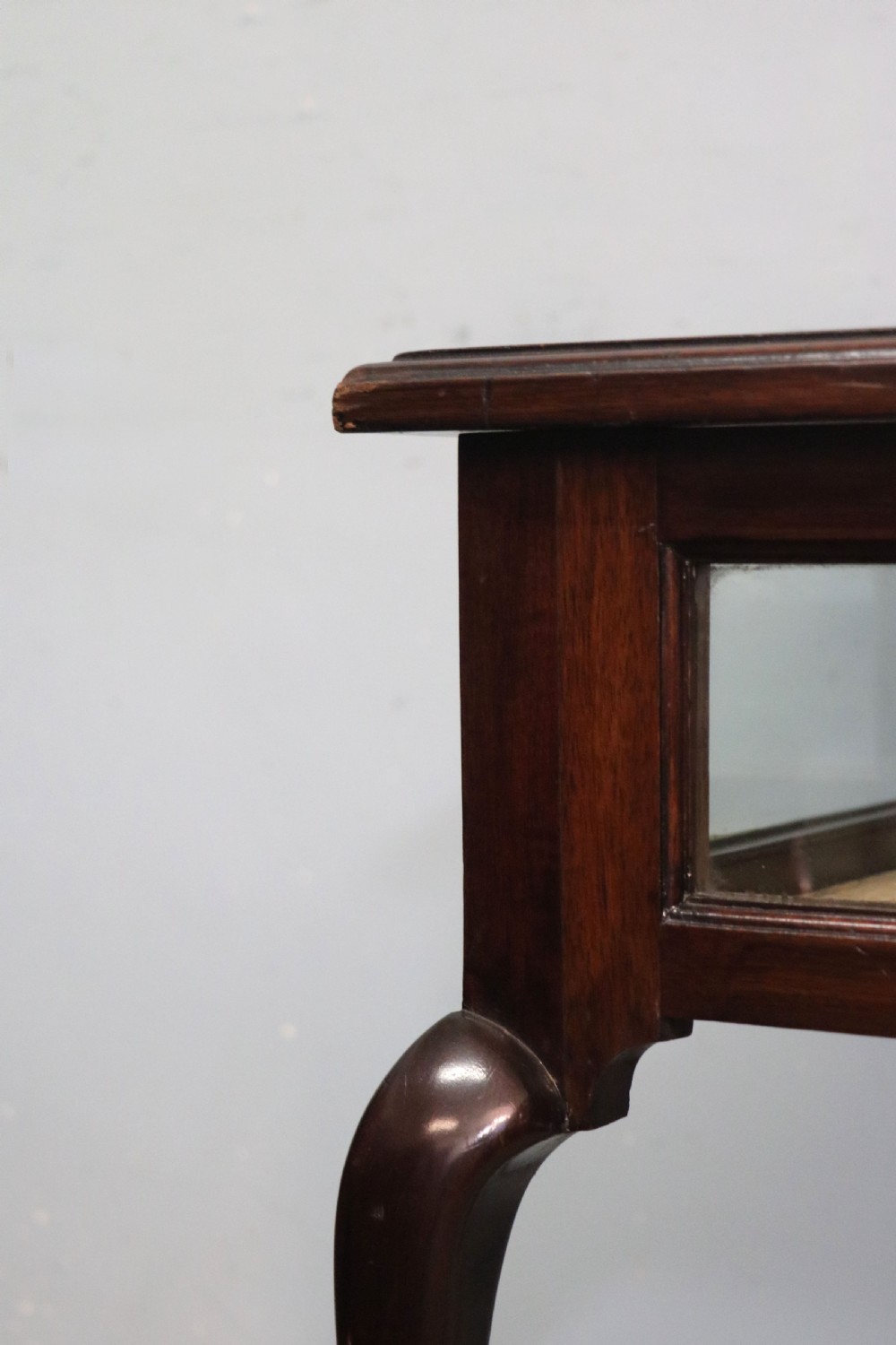 A dark mahogany glazed bijouterie table featuring cabriole legs, a glass top with blue Breitling watch branding, and a lined interior display compartment. View XIV