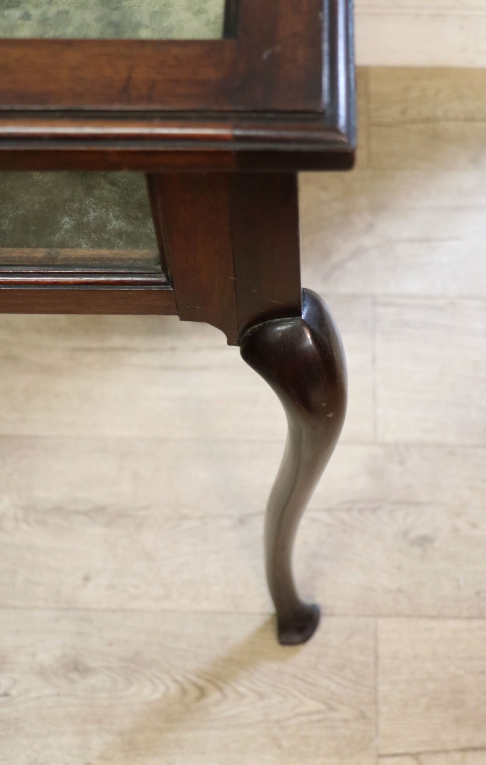 A dark mahogany glazed bijouterie table featuring cabriole legs, a glass top with blue Breitling watch branding, and a lined interior display compartment. View XV