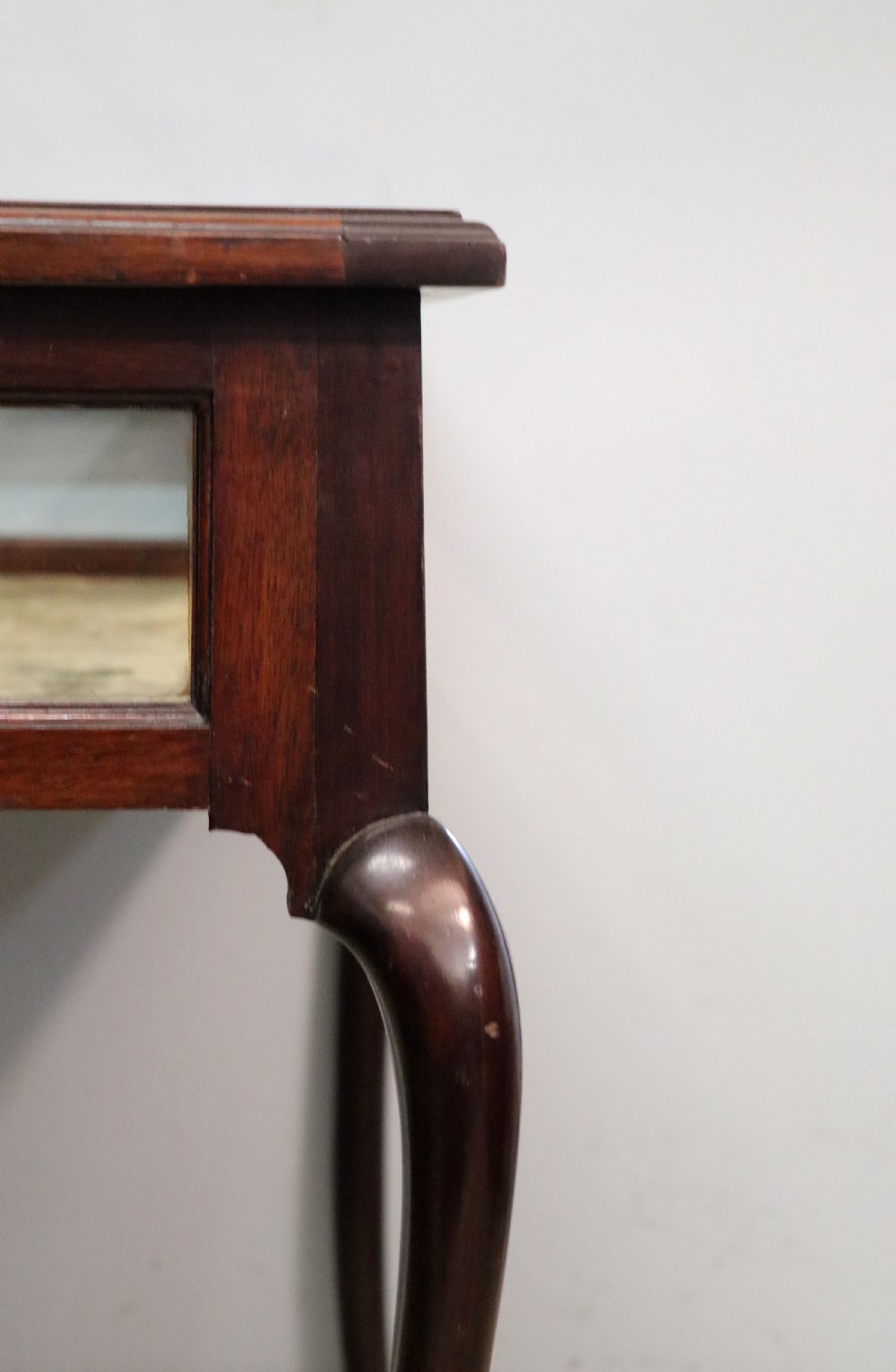 A dark mahogany glazed bijouterie table featuring cabriole legs, a glass top with blue Breitling watch branding, and a lined interior display compartment. View XVI