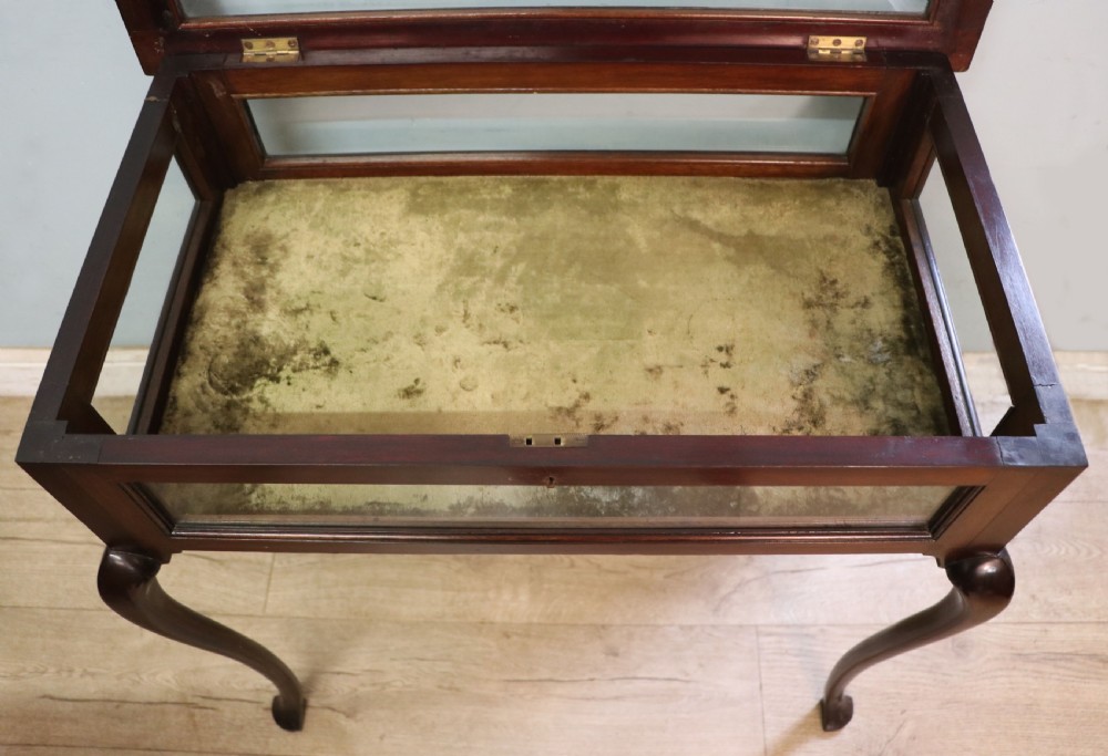 A dark mahogany glazed bijouterie table featuring cabriole legs, a glass top with blue Breitling watch branding, and a lined interior display compartment. View XVII