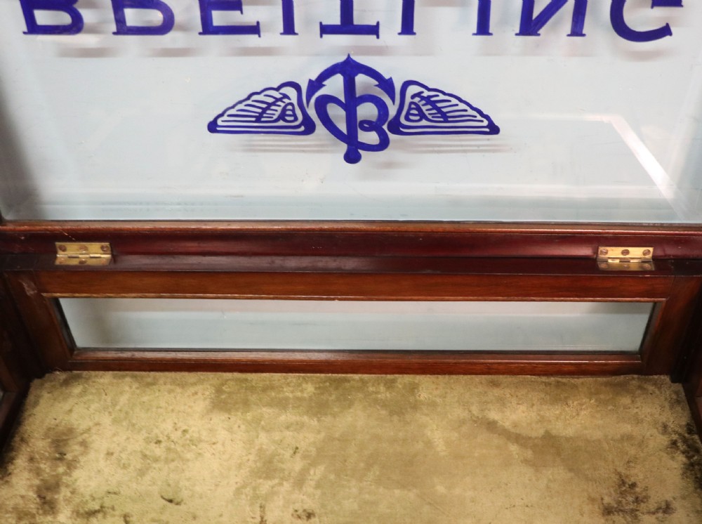 A dark mahogany glazed bijouterie table featuring cabriole legs, a glass top with blue Breitling watch branding, and a lined interior display compartment. View XVIII