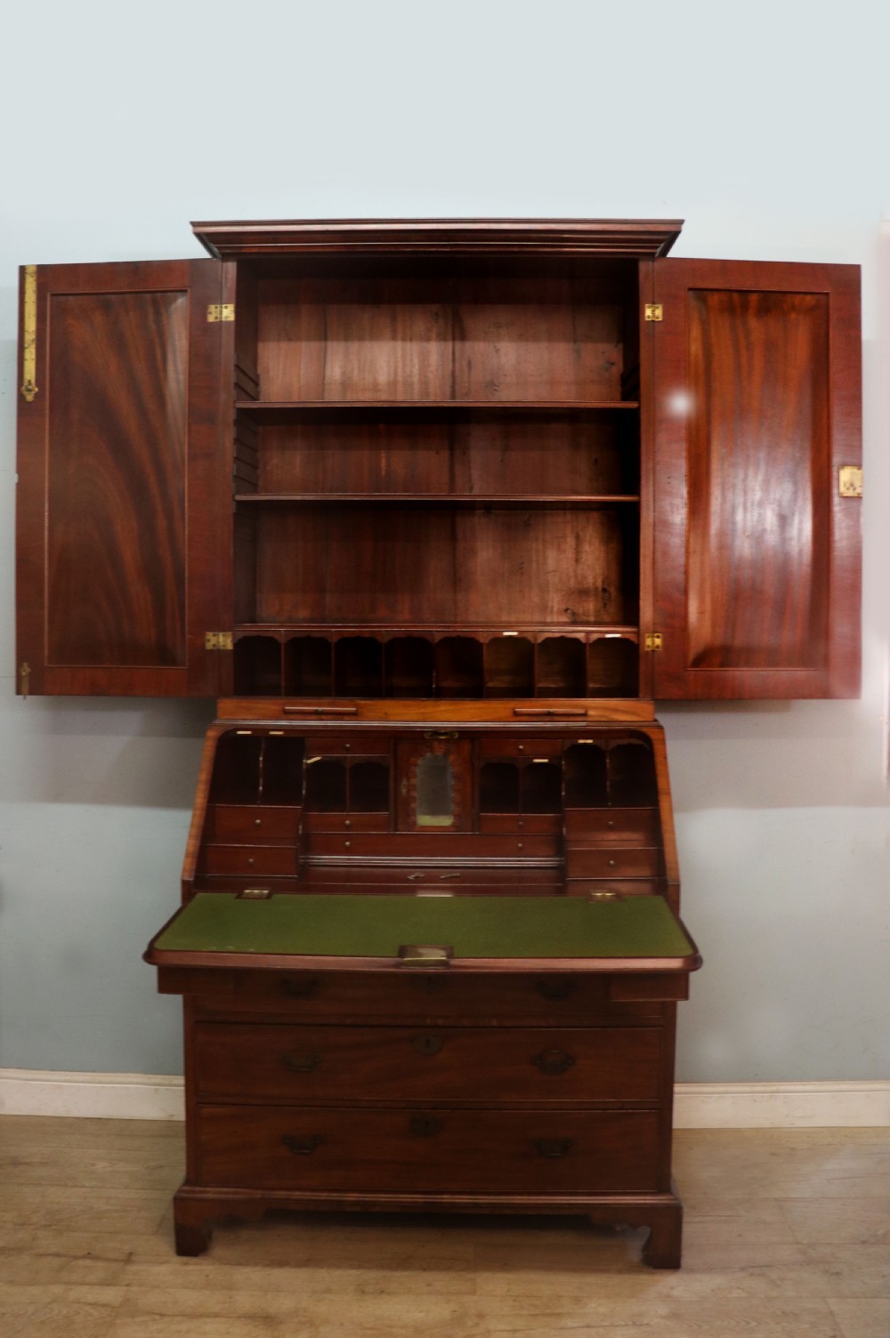 A George III mahogany bureau bookcase featuring a panelled upper cabinet above a fall-front writing surface and graduated drawers with brass hardware. View III