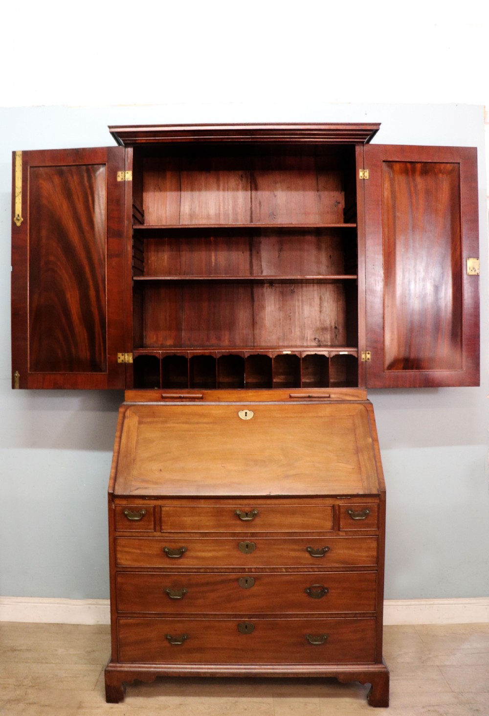 A George III mahogany bureau bookcase featuring a panelled upper cabinet above a fall-front writing surface and graduated drawers with brass hardware. View VI