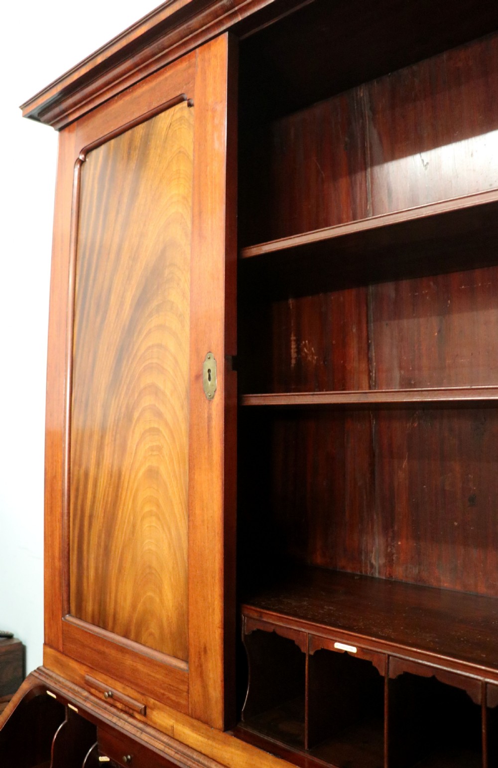 A George III mahogany bureau bookcase featuring a panelled upper cabinet above a fall-front writing surface and graduated drawers with brass hardware. View XIV