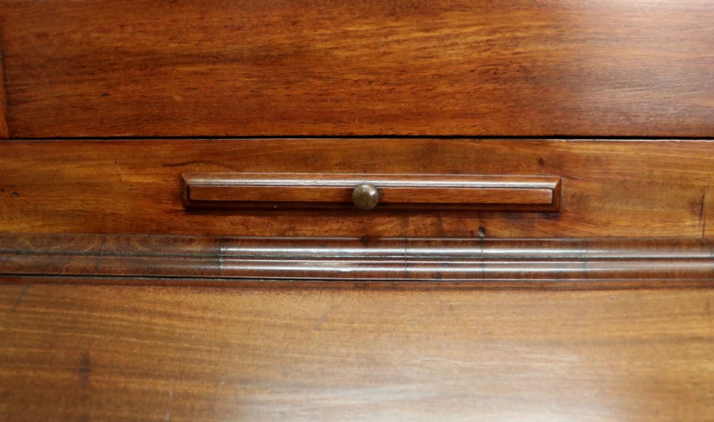 A George III mahogany bureau bookcase featuring a panelled upper cabinet above a fall-front writing surface and graduated drawers with brass hardware. View XVII