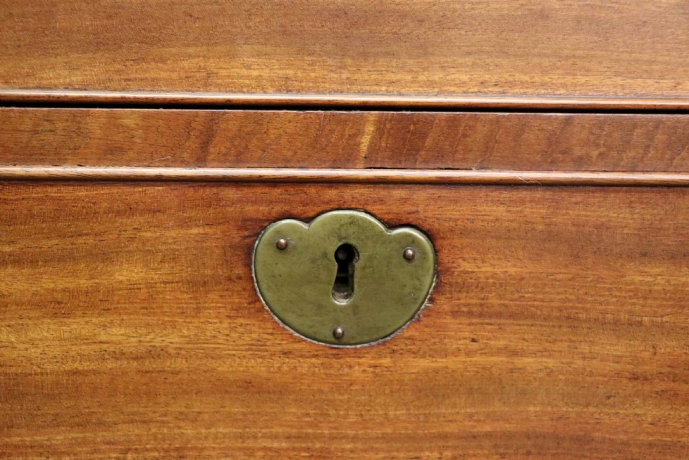 A George III mahogany bureau bookcase featuring a panelled upper cabinet above a fall-front writing surface and graduated drawers with brass hardware. View XIX