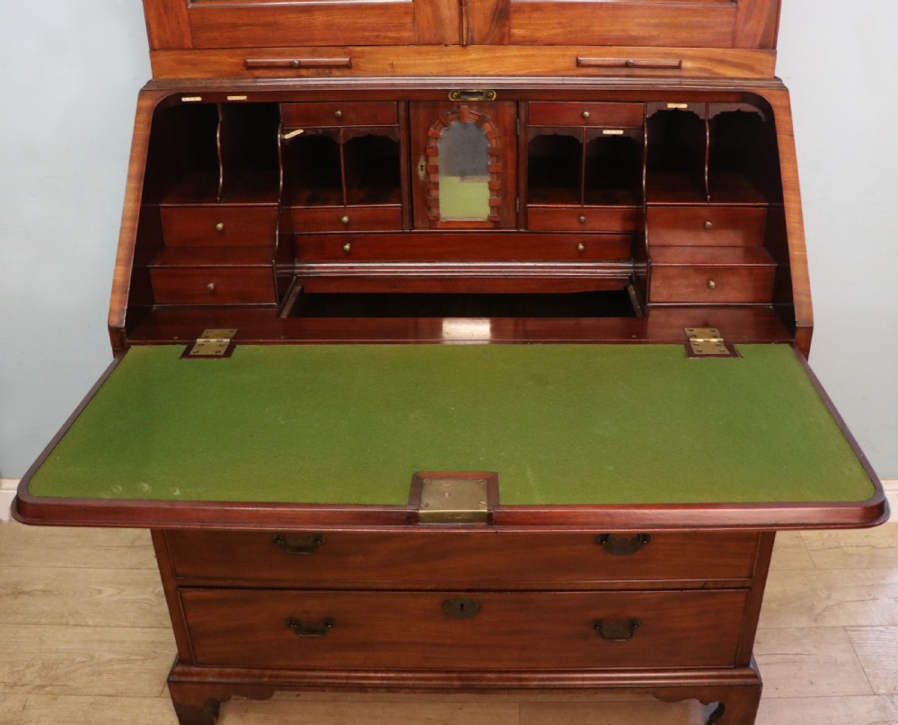 A George III mahogany bureau bookcase featuring a panelled upper cabinet above a fall-front writing surface and graduated drawers with brass hardware. View XXII