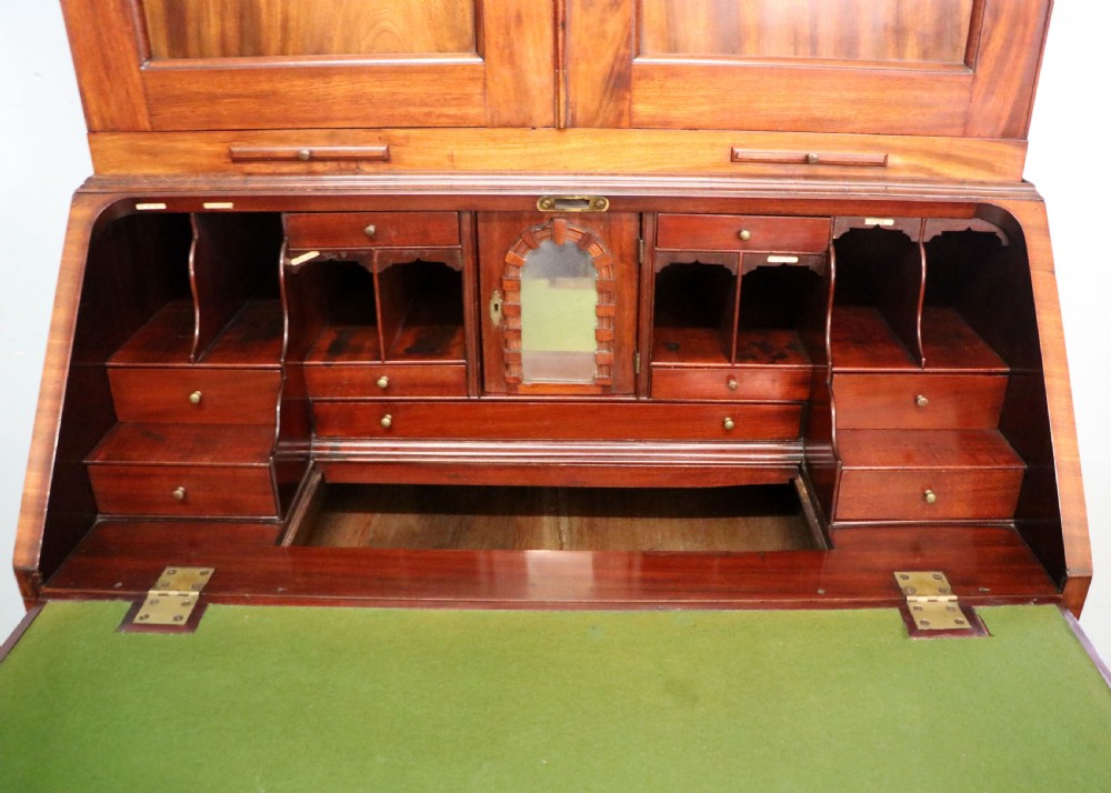 A George III mahogany bureau bookcase featuring a panelled upper cabinet above a fall-front writing surface and graduated drawers with brass hardware. View XXIV