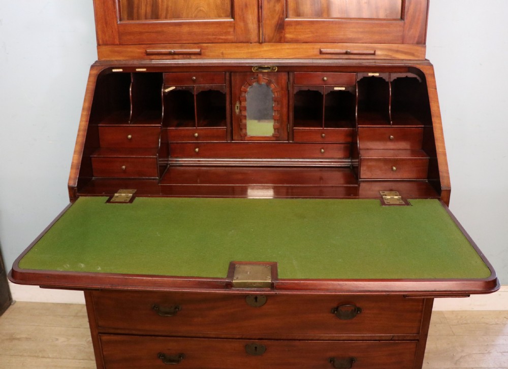A George III mahogany bureau bookcase featuring a panelled upper cabinet above a fall-front writing surface and graduated drawers with brass hardware. View XXV