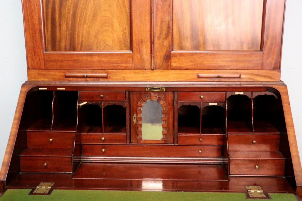 A George III mahogany bureau bookcase featuring a panelled upper cabinet above a fall-front writing surface and graduated drawers with brass hardware. View XXVII
