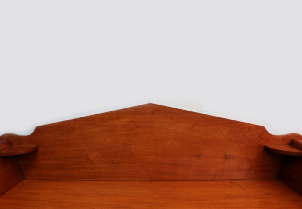 A mid-nineteenth century mahogany chest of drawers featuring two short drawers over two long drawers, turned wooden handles, and a shaped galleried backboard. View VII