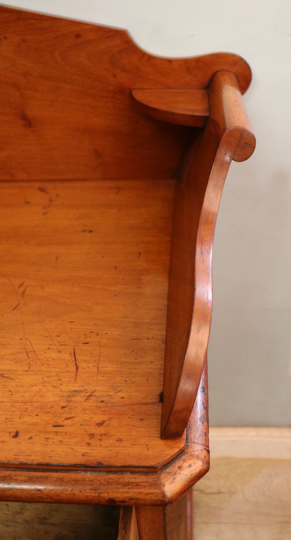 A mid-nineteenth century mahogany chest of drawers featuring two short drawers over two long drawers, turned wooden handles, and a shaped galleried backboard. View XI
