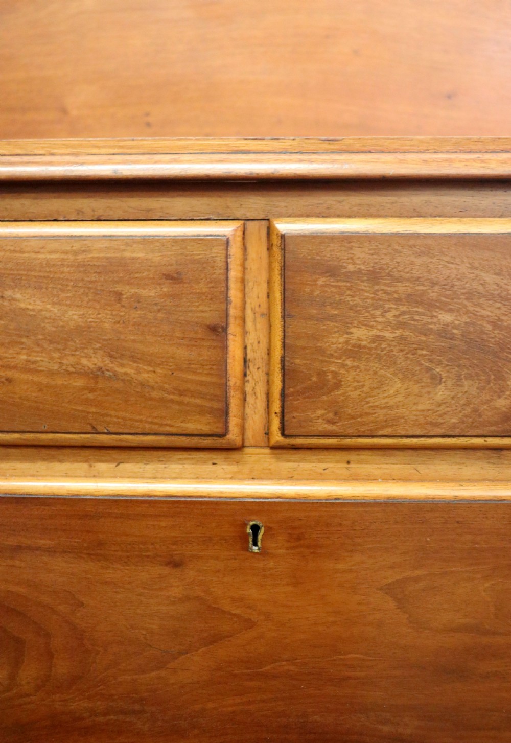 A mid-nineteenth century mahogany chest of drawers featuring two short drawers over two long drawers, turned wooden handles, and a shaped galleried backboard. View XIV