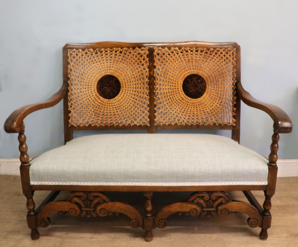  A charming early 20th century two-seater solid oak framed sofa modelled in the late 17th century style. 