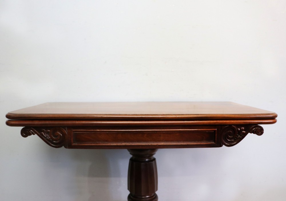 An early 19th-century mahogany tea table featuring a hinged fold-over top, turned central column, and four splayed legs with brass castors. View VIII