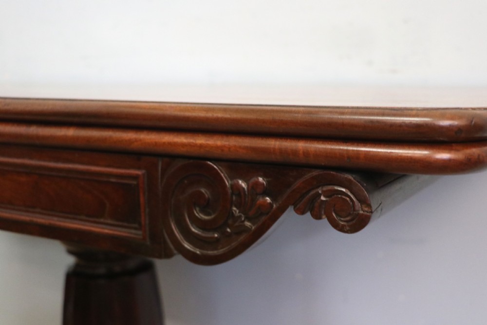 An early 19th-century mahogany tea table featuring a hinged fold-over top, turned central column, and four splayed legs with brass castors. View XI