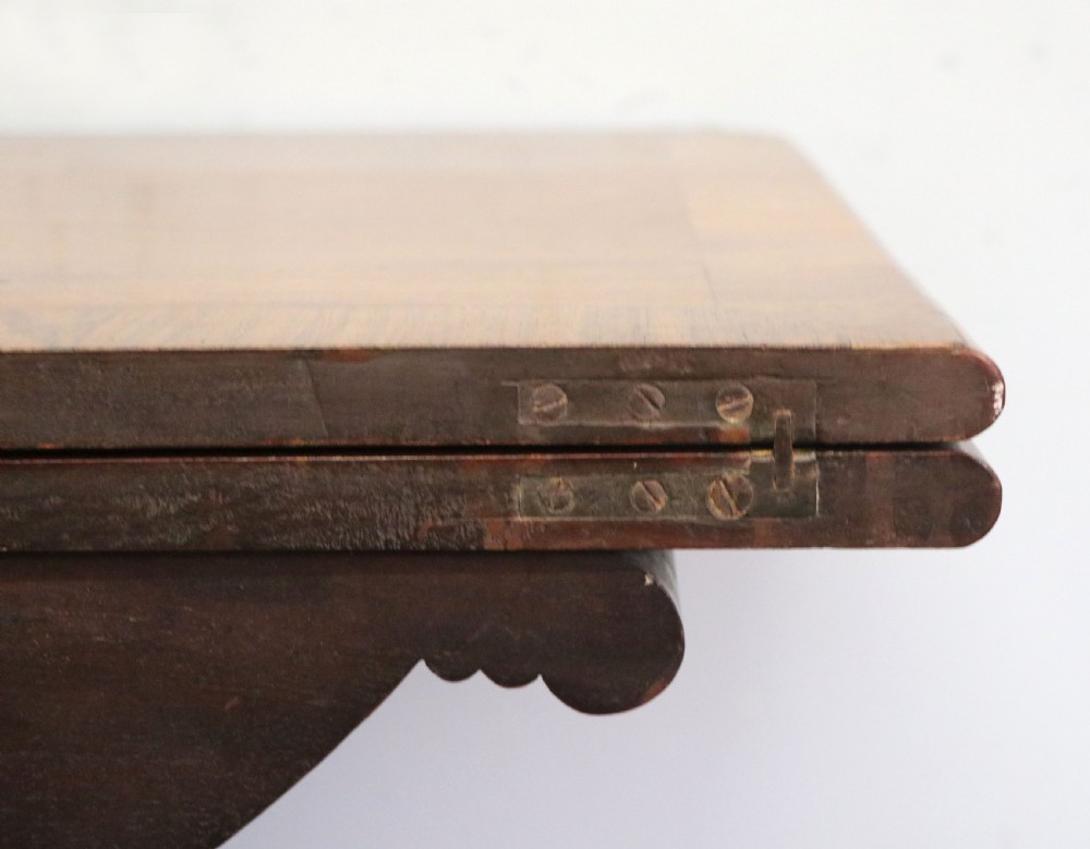 An early 19th-century mahogany tea table featuring a hinged fold-over top, turned central column, and four splayed legs with brass castors. View XVIII