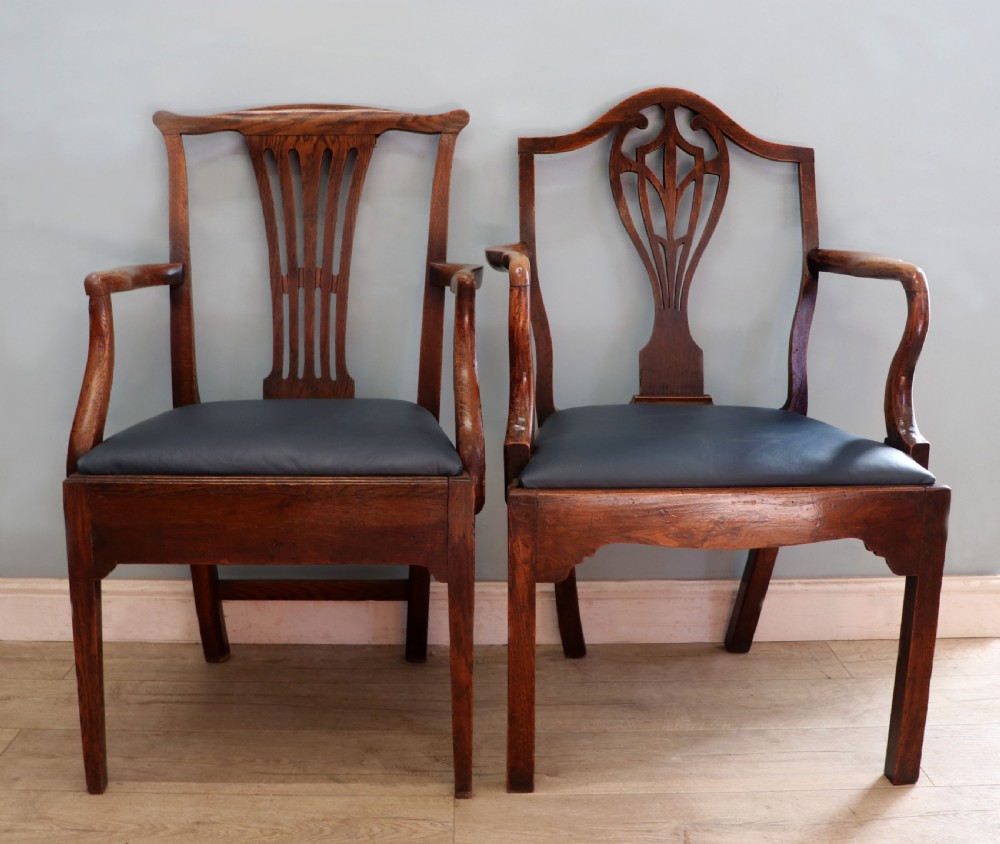 A pair of early 19th century dark timber carver chairs featuring open pierced splats, swept armrests, and dark upholstered seats. View II
