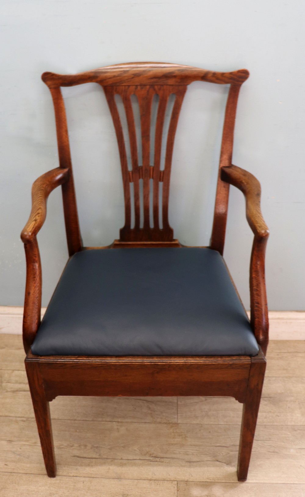 A pair of early 19th century dark timber carver chairs featuring open pierced splats, swept armrests, and dark upholstered seats. View IV