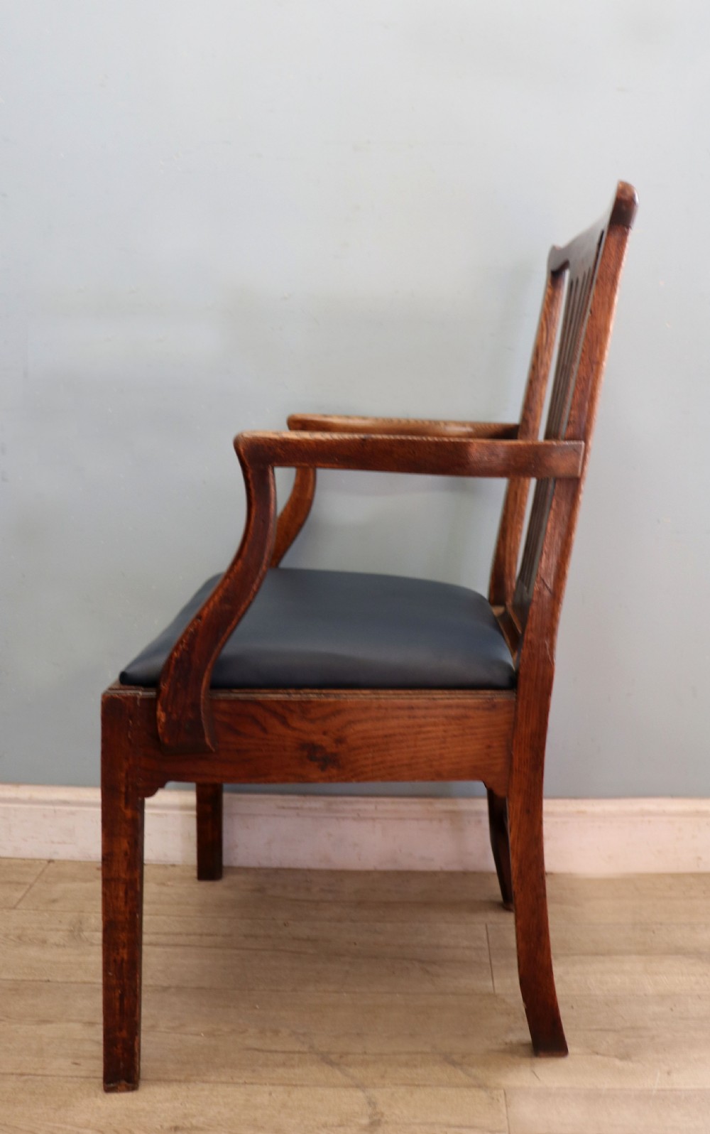 A pair of early 19th century dark timber carver chairs featuring open pierced splats, swept armrests, and dark upholstered seats. View VIII
