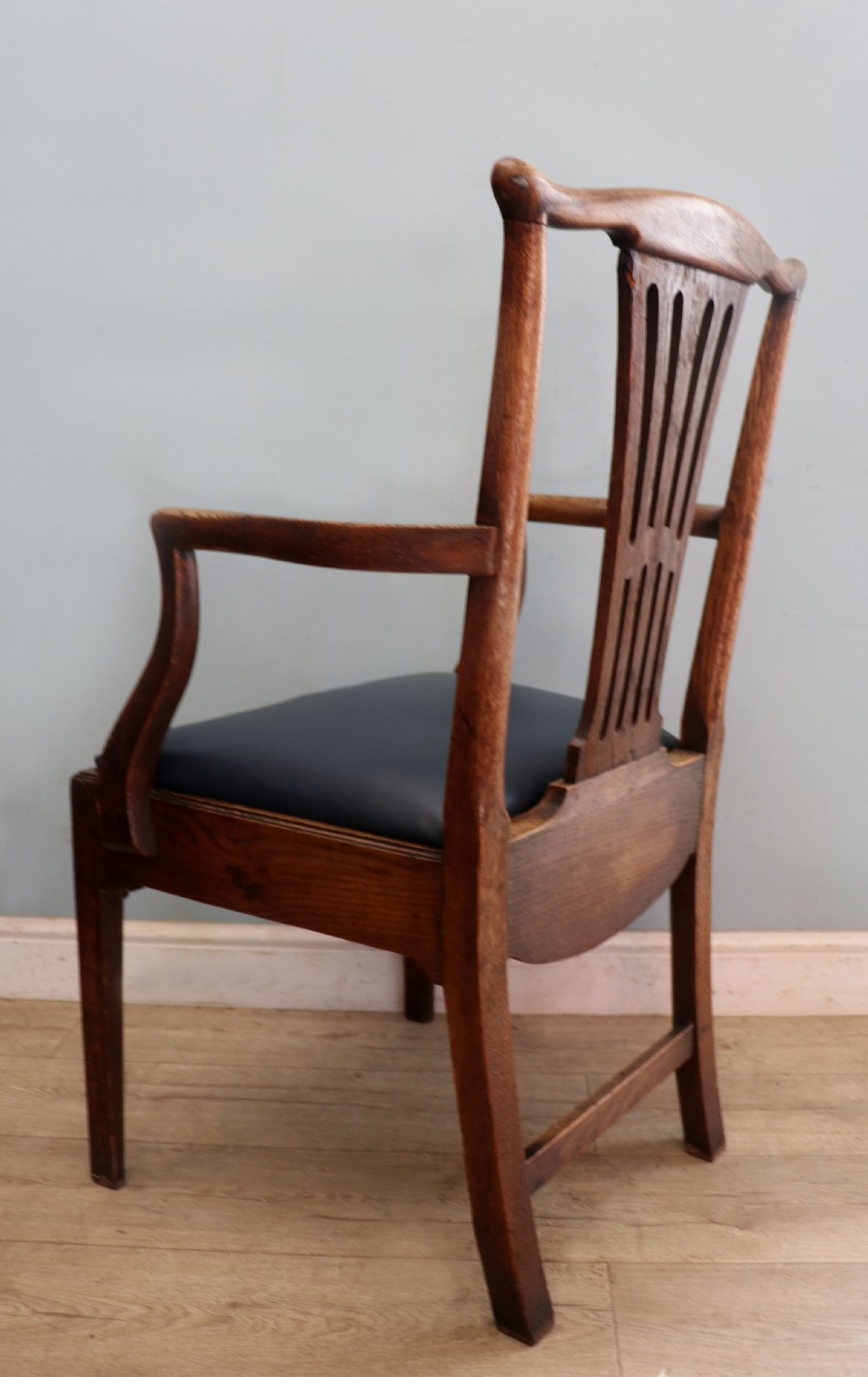 A pair of early 19th century dark timber carver chairs featuring open pierced splats, swept armrests, and dark upholstered seats. View IX