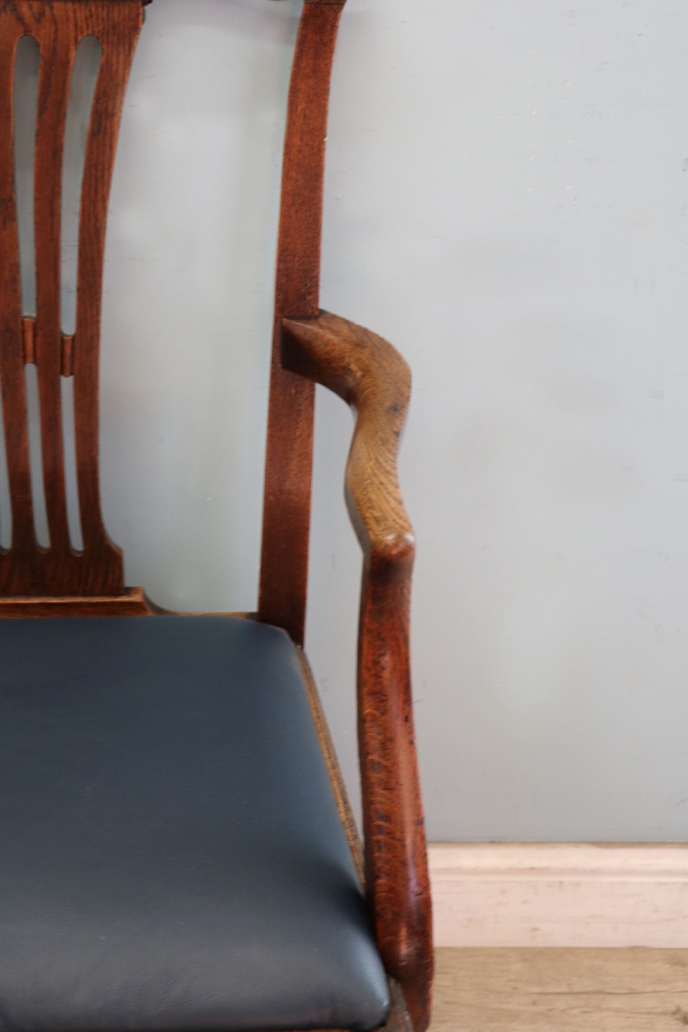 A pair of early 19th century dark timber carver chairs featuring open pierced splats, swept armrests, and dark upholstered seats. View XII